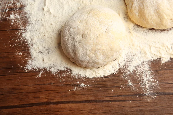 Bolas de masa para pizza sobre tabla de madera enharinada —  Fotos de Stock