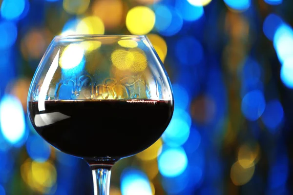 Ein Glas Rotwein auf unscharf beleuchtetem Hintergrund — Stockfoto