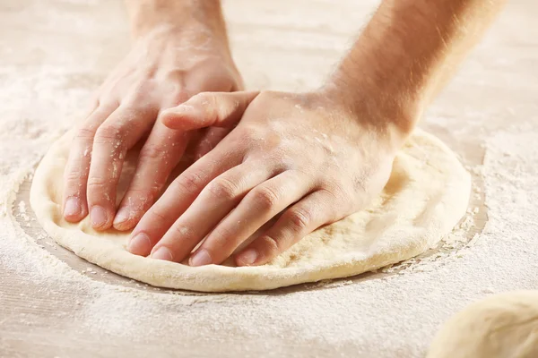 Mãos que preparam a base de massa de farinha de pizza — Fotografia de Stock