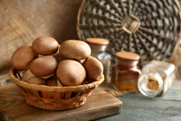 Cogumelos em cesta na superfície de madeira — Fotografia de Stock