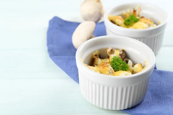 Piatto francese julienne. Fungo, pollo e formaggio gratinato in ciotole di ceramica, su fondo di legno — Foto Stock