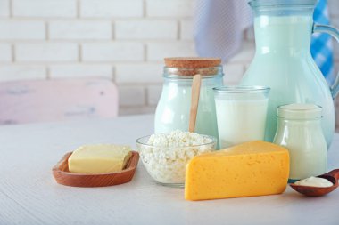 Tuğla duvar arka plan üzerinde ahşap masa üzerinde süt ürünleri