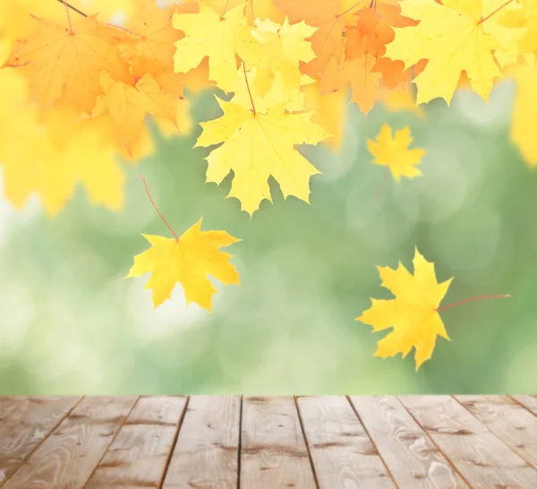 Autumnal leaves with bokeh and wooden floor. — Stock Photo, Image