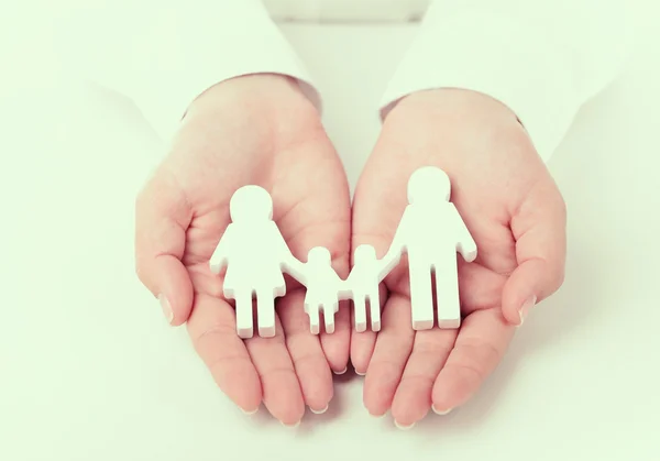 Женщины держат в руках игрушечную семью — стоковое фото