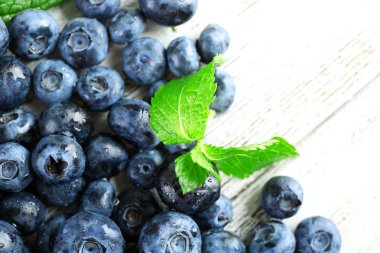 Ahşap masa üzerinde yeşil yaprakları ile lezzetli olgun yaban mersini yakın çekim