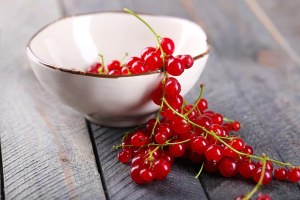 Groseilles rouges fraîches dans un bol sur une table en bois fermer — Photo