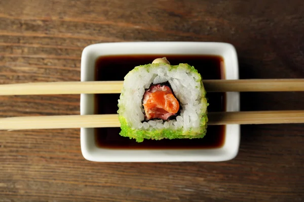 Rollen met saus en stokken op houten tafel close-up — Stockfoto