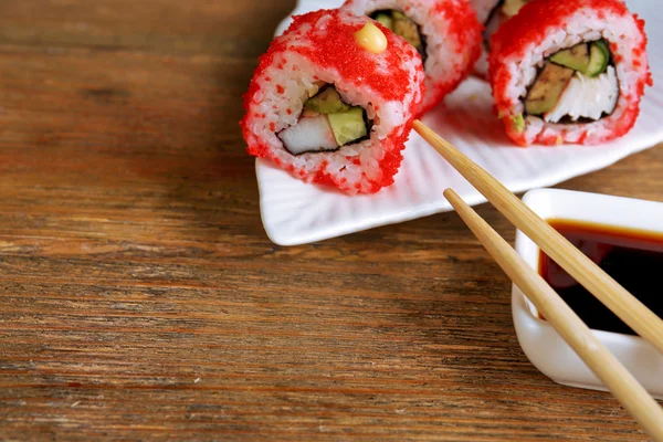 Rouleaux avec sauce et bâtons sur table en bois fermer — Photo