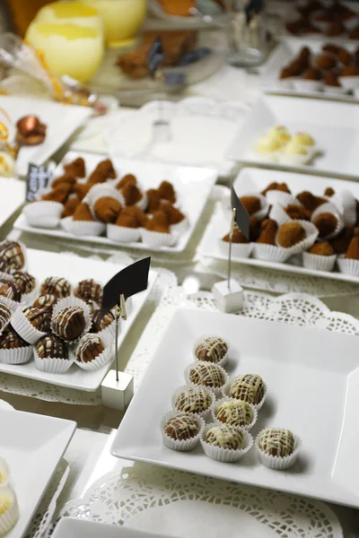 Deliciosos doces de chocolate em pratos na mesa de perto — Fotografia de Stock