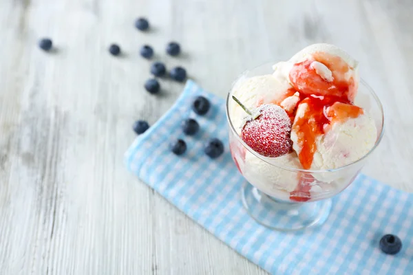 Delicioso sorvete com frutas frescas congeladas e molho, na cor de fundo de madeira — Fotografia de Stock