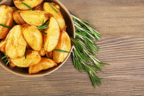 Cunhas de batata assadas na mesa de madeira, vista superior — Fotografia de Stock