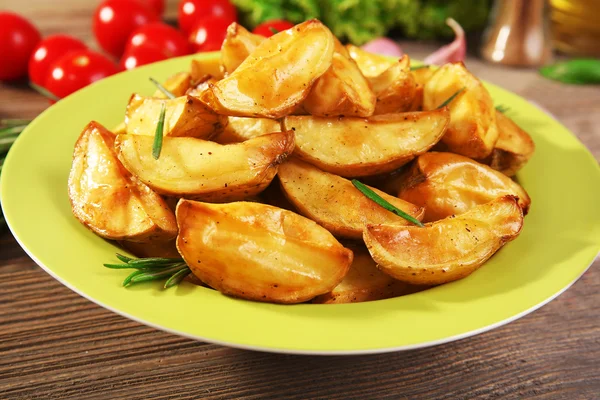 Baked potato wedges on wooden table, closeup — Stock Photo, Image