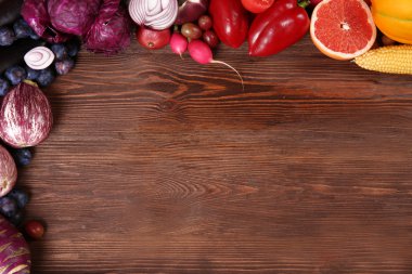 Parlak meyve ve sebze ahşap zemin üzerine yapılmış bir çerçeve