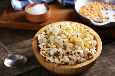 Ahşap masa mutfak ekipman ile dekore edilmiş bir kase tuzlu popcorn