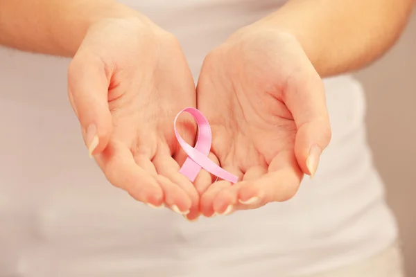 Hands holding pink ribbon sign — Stock Photo, Image