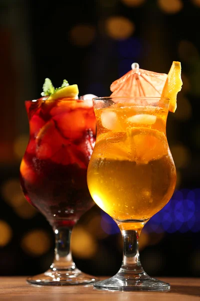 Glasses of cocktail on dark blurred lights background — Stock Photo, Image