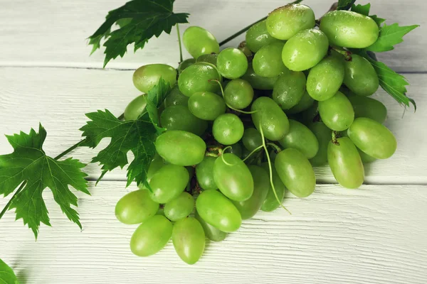 堆的白色木制背景上的白葡萄品种 — 图库照片