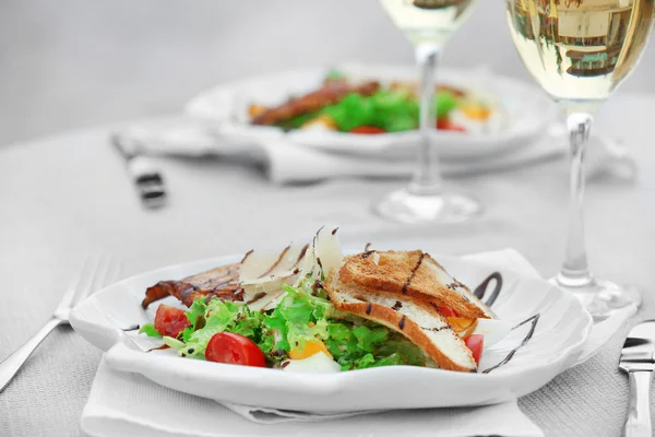 Ensalada sabrosa con vino sobre mesa blanca servida — Foto de Stock