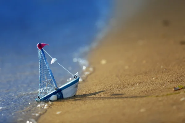 Маленькая лодка на берегу моря — стоковое фото
