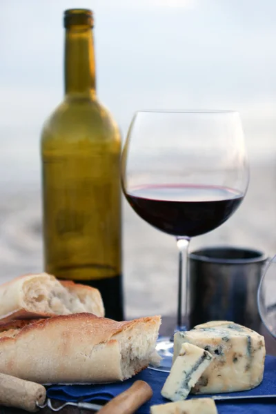 Hermosa composición romántica de vino tinto, pan y nueces en la playa de arena, de cerca —  Fotos de Stock
