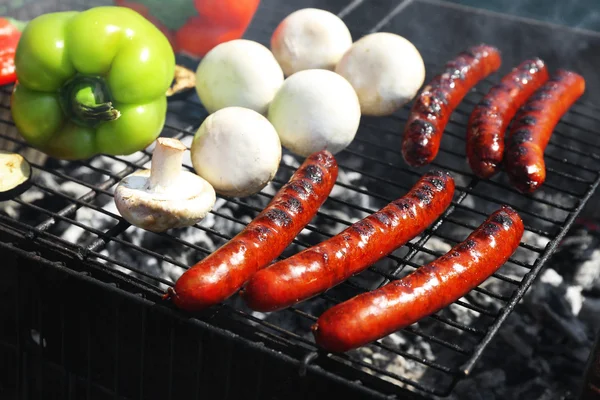 Pølser og grøntsager på grill closeup - Stock-foto