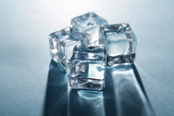 Shining ice cubes on grey-blue background — Stock Photo, Image