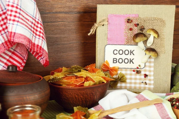 Decorated composition of cookery book and kitchen equipment on wooden background, close up — Stock Photo, Image