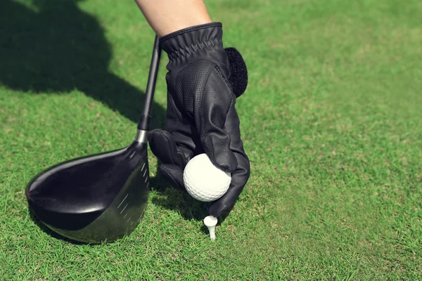 Hand i svart handske med golf club och bollen — Stockfoto