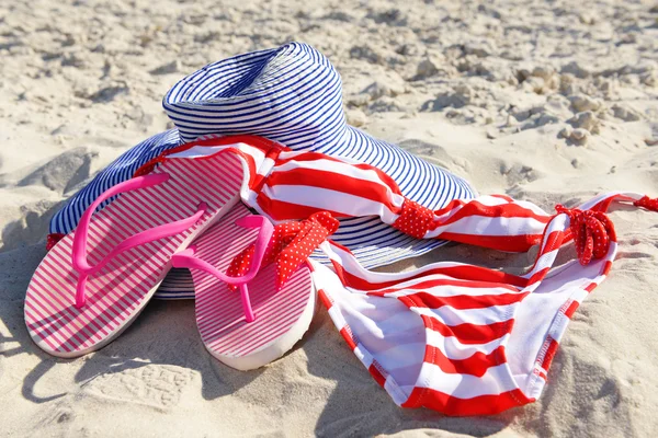 Flip flops and hat on beach — Stock Photo, Image