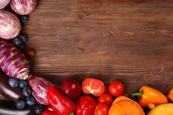 A frame made of bright fruit and vegetables on wooden background — Stock Photo, Image