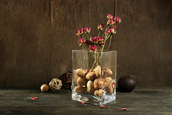 Composition of nuts, wooden balls and stale flowers — Stock Photo, Image