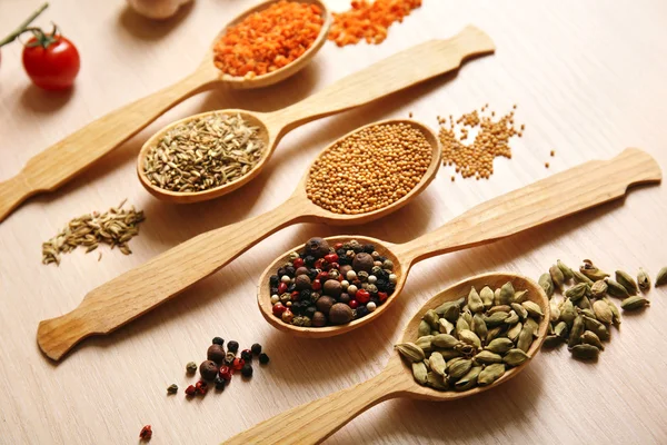 Mängd olika kryddor i skedar på köksbordet — Stockfoto