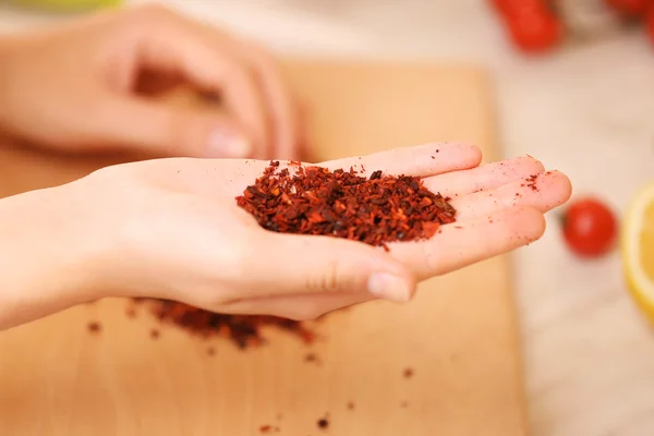 Paprika rouge sur la main dans la cuisine — Photo