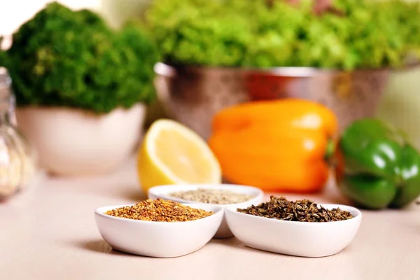 Mängd olika kryddor i keramiska behållare på köksbordet — Stockfoto