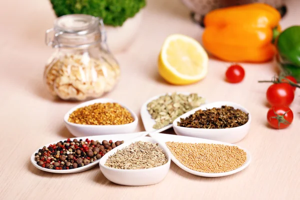 Variedade de especiarias em recipientes de cerâmica na mesa da cozinha — Fotografia de Stock