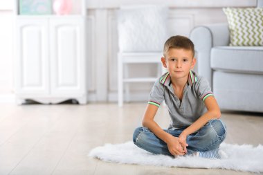 küçük çocuk halı üzerinde oturan