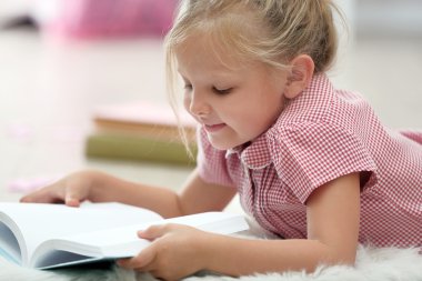 Küçük kız kitap okuyor.
