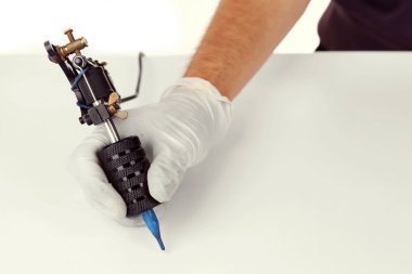 Erkeğin elinde dövme makinesi  