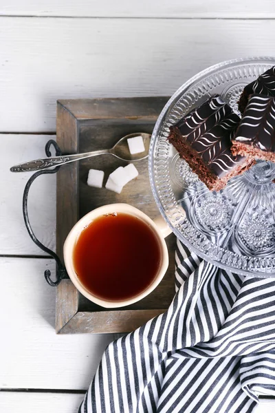 Mesa servida con una taza de té y pasteles de chocolate de cerca — Foto de Stock