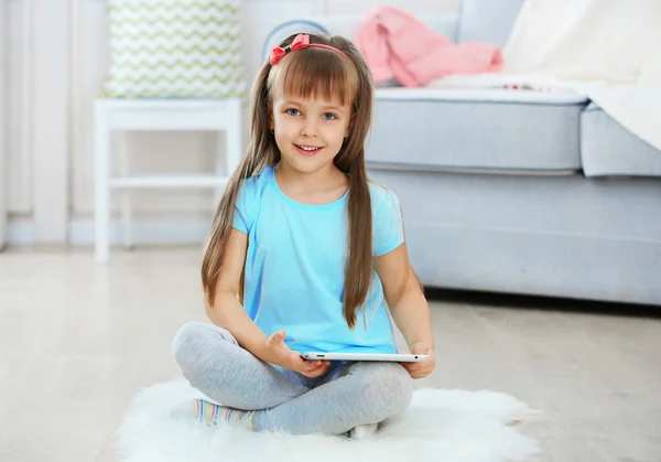 Маленькая милая девочка с цифровым планшетом — стоковое фото