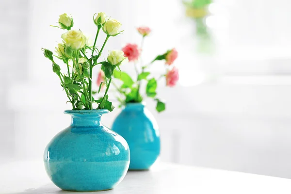 Schöne Rosen in türkisfarbenen Vasen auf Fensterhintergrund — Stockfoto