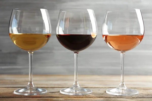 Weingläser in einer Reihe auf Holztisch — Stockfoto