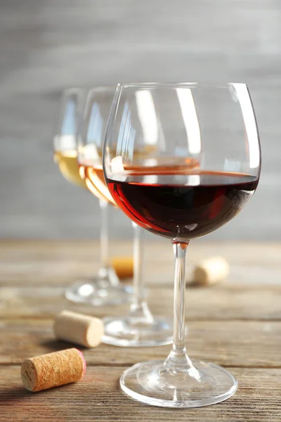 Wine glasses in a row and corks — Stock Photo, Image