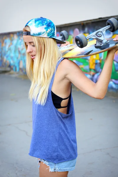 Mujer joven con tabla de patinar — Foto de Stock