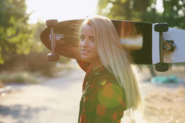 Mujer joven con tabla de patinar — Foto de Stock