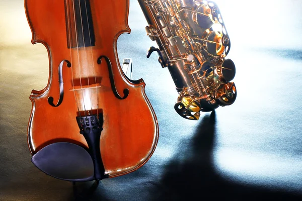 Hermoso saxofón dorado con violín en una escena — Foto de Stock