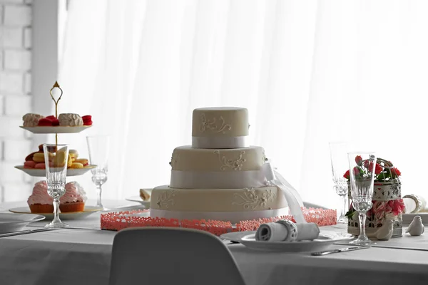 Весільний багатошаровий торт на декорованому столі в ресторані — стокове фото