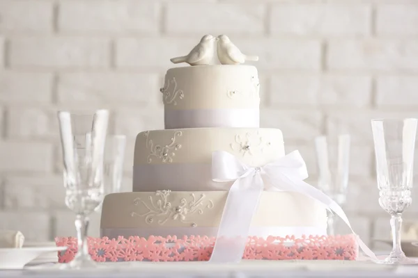 Wedding layered cake in decorated restaurant on white wall background