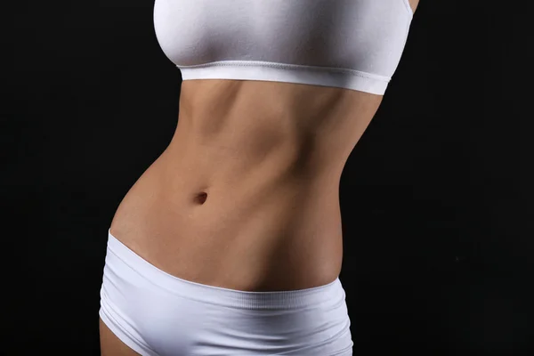 Magro corpo feminino em lingerie branca agradável no fundo preto — Fotografia de Stock