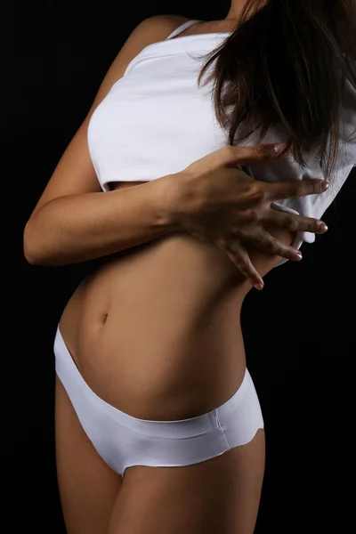 Štíhlé ženské tělo v pěkné bílé prádlo na černém pozadí — Stock fotografie